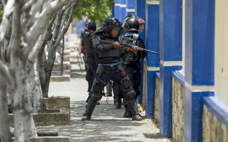 Policías disparando a estudiantes atrincherados en la Universidad de Ingeniería. Foto: tomada de El Diario Metro