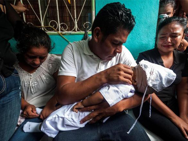 Nelson Lorío sosteniendo a su bebé que murió a causa de un impacto de bala en la cabeza. Foto: Diario Metro