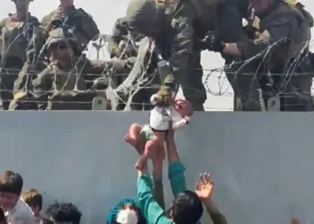 Un bebé afgano es entregado por encima de un muro en Kabul a soldados de EEUU. Foto: Tomada de Internet.