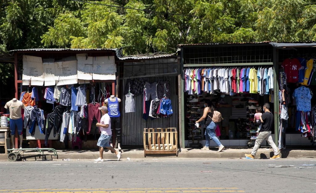 Personas caminan frente a un comercio de ropa en el mercado oriental en Managua (Nicaragua), en una fotografía de archivo. EFE/Jorge Torres