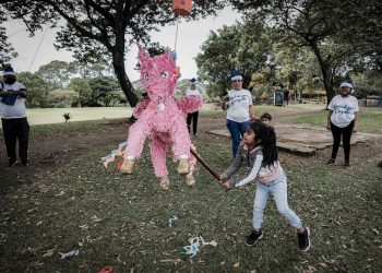 Una niña rompe una piñata en una fiesta navideña para familias de exiliados, en un parque en San José, Costa Rica. Foto: Artículo 66 / EFE