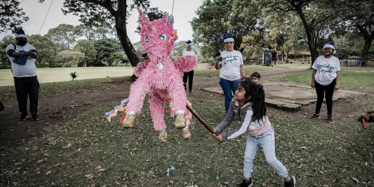 Una niña rompe una piñata en una fiesta navideña para familias de exiliados, en un parque en San José, Costa Rica. Foto: Artículo 66 / EFE