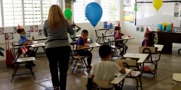 Una maestra imparte una clase a un reducido número de alumnos de la Escuela Eugenio María de Hostos en Cayey, en Cayey (Puerto Rico), en una fotografía de archivo.