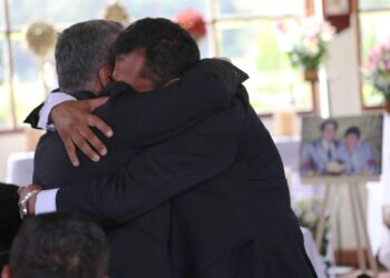 Fotografía cedida por la Unidad de Búsqueda de Personas dadas por Desaparecidas que muestra a familiares de Carmenza Castañeda de Angulo mientras se abrazan en la ceremonia de entrega de sus restos.