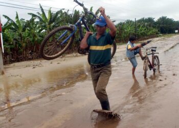 La alerta amarilla prevé evacuaciones preventivas en regiones con riesgo de deslizamientos, derrumbes, inundaciones o desbordamiento de río. En la imagen un registro de archivo de dos afectados por las lluvias en el municipio de Tocoa (Honduras). EFE