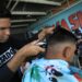 El migrante de origen venezolano, José Miguel Ceballos, corta el cabello a una persona el 11 de noviembre de 2022 en Ciudad Juárez, Chihuahua (México). EFE