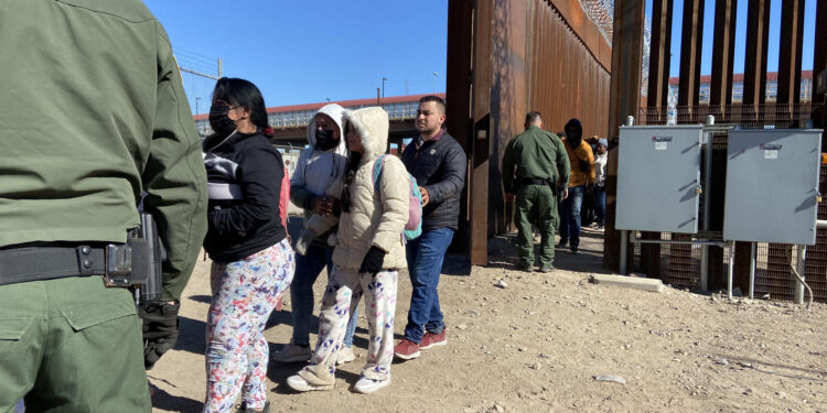 Migrantes mientras hacen fila para entregarse a la Patrulla Fronteriza estadounidense hoy, en la valla fronteriza de El Paso, Texas, frente a Ciudad Juárez, México. EFE/Octavio Guzmán