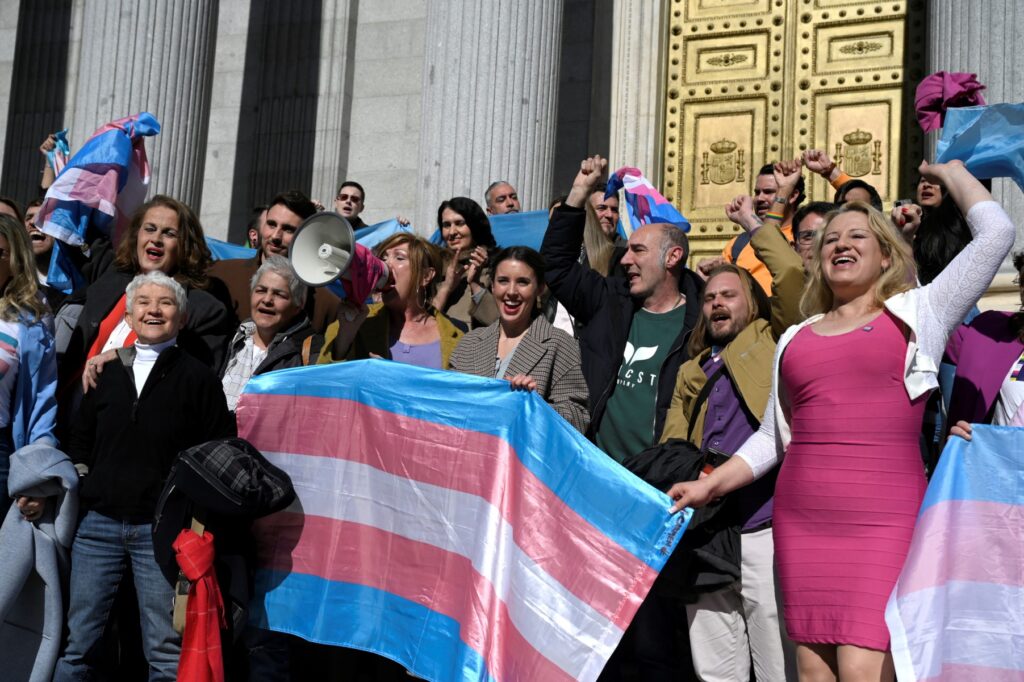 La activista Carla Antonelli (L), la activista Boti García (2L), el presidente LGTBI+ de España Uge Sangil (3L), la ministra de Igualdad de España Irene Montero (C) y la miembro LGTBI+ Niurka Gibaja (R) celebran frente al Congreso español, en Madrid el 16 de febrero de 2023 después de que se votara la 'ley transgénero'. - España adoptó una ley que simplifica el proceso de autoidentificación como transgénero, otros pioneros están frenando las complejidades involucradas en este tema tan sensible. El proyecto de ley de derechos transgénero permite que cualquier persona mayor de 16 años cambie el género en su tarjeta de identificación. (Foto por ÓSCAR DEL POZO / AFP)