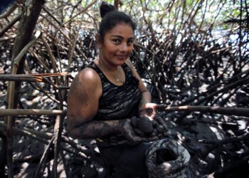Elena Martínez, residente del poblado de Aserradores, Costa del Pacífico de Nicaragua, muestra conchas negras recolectadas en un manglar, las cuales luego venderá a turistas y restaurantes de la zona el 6 de febrero de 2023.
