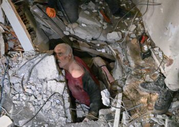 A man trapped in rubble reacts while debris is removed to work on his rescue in Hatay on February 7, 2023, a day after a 7,8-magnitude earthquake struck the country's southeast. - Rescuers in Turkey and Syria braved frigid weather, aftershocks and collapsing buildings, as they dug for survivors buried by an earthquake that killed more than 5,000 people. Up to 23 million people could be affected by the massive earthquake that has killed thousands in Turkey and Syria, the WHO warned on Tuesday, promising long-term assistance. (Photo by BULENT KILIC / AFP)