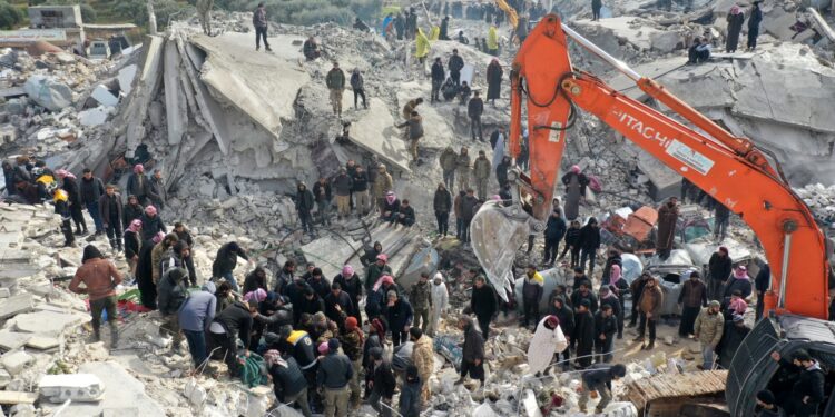This aerial view shows residents, aided by heavy equipment, searching for victims and survivors amidst the rubble of collapsed buildings following an earthquake in the village of Besnia near the twon of Harim, in Syria's rebel-held noryhwestern Idlib province on the border with Turkey, on February 6, 2022. - Hundreds have been reportedly killed in north Syria after a 7.8-magnitude earthquake that originated in Turkey and was felt across neighbouring countries. (Photo by Omar HAJ KADOUR / AFP)
