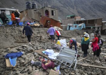 Residentes del aislado pueblo de Camaná, 840 kilómetros al sur de Lima, caminan entre los escombros que dejó un deslizamiento de tierra en Perú el 6 de febrero de 2023. Los deslizamientos de tierra en el sur de Perú han dejado al menos 15 muertos, 20 heridos y dos desaparecidos, dijeron las autoridades. el lunes, advirtiendo que el número de víctimas del desastre podría aumentar. "El número de muertos hasta el momento asciende a 15", informó la dirección del Instituto Nacional de Defensa Civil en la región de Arequipa, donde el domingo comenzaron deslizamientos de lodo y rocas producto de las lluvias torrenciales. (Foto de Diego Ramos / AFP)