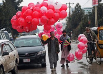 Los vendedores afganos que venden globos esperan a los clientes a lo largo de una calle con motivo del Día de San Valentín en Mazar-i-Shrif el 14 de febrero de 2023. - El Día de San Valentín nunca se ha celebrado ampliamente en Afganistán, algunos residentes acomodados en las ciudades han desarrollado una tradición. de conmemorar el día de los enamorados en los últimos años. (Foto de Atif ARYAN / AFP)