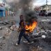 A mans walks past a burning barricade during a protest against Haitian Prime Minister Ariel Henry calling for his resignation, in Port-au-Prince, Haiti, October 10, 2022. - Protests and looting have rocked the already unstable country since September 11, when Prime Minister Ariel Henry announced a fuel price hike. (Photo by Richard Pierrin / AFP)