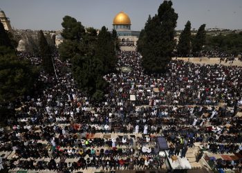 La gente realiza la primera oración del mediodía del viernes del mes de ayuno islámico del Ramadán, frente al santuario de la Cúpula de la Roca en el recinto de la mezquita de Al-Aqsa en Jerusalén, el 24 de marzo de 2023. (Foto de AHMAD GHARABLI / AFP)