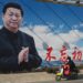 En esta foto de archivo tomada el 28 de febrero de 2023, un hombre pasa en scooter frente a una valla publicitaria que muestra al presidente de China, Xi Jinping, con un eslogan que dice "Permanecer fieles a nuestra aspiración original y tener nuestra misión firmemente en mente" en Beijing. - El líder de China, Xi Jinping, se deslizará hacia su tercer mandato en el poder magullado pero imperturbable por las protestas masivas, la ola mortal de Covid y el malestar económico que han afectado a su gobierno en los últimos meses. (Foto de Jade Gao / AFP)