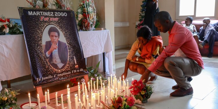 En esta foto de archivo tomada el 23 de enero de 2023, los dolientes colocan velas en una sala de Radio Amplitude FM donde se ha colocado un retrato del periodista Martínez Zogo para rendirle homenaje. Foto: AFP