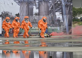 Rescuers in protective equipments walk past a mock collapsed nuclear power plant during a civilian drill while imitating a Chinese attack in Taichung on April 13, 2023. - More then 1,000 people took part in the drill organized by Taichung government. (Photo by Sam Yeh / AFP)