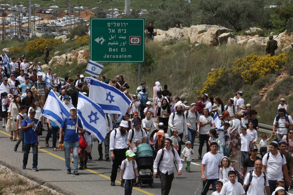 Colonos israelíes marchan hacia el puesto avanzado de Eviatar, cerca de la aldea palestina de Beita, al sur de Naplusa, en la Cisjordania ocupada, el 10 de abril de 2023. (Foto de GIL COHEN-MAGEN / AFP)