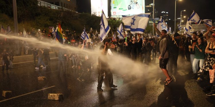 La policía israelí rocía agua a los manifestantes durante una manifestación contra el proyecto de ley de reforma judicial del gobierno en Tel Aviv el 1 de abril de 2023. (Foto de JACK GUEZ / AFP)