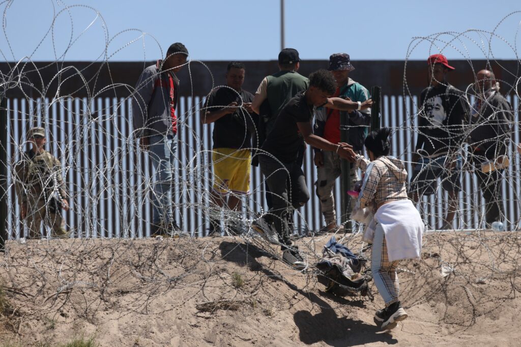Migrantes cruzan las orillas del Río Grande para ser procesados por la Patrulla Fronteriza Sector El Paso, Texas, luego de cruzar desde Ciudad Juárez, México, el 8 de mayo de 2023.