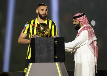 Former Real Madrid striker Karim Benzema hoists the Ballon d'Or, the trophy he won last year, above his head, at King Abdullah Sports City stadium in Jeddah, on June 8, 2023. - Benzema was unveiled as an Al-Ittihad player in front of thousands of fans in Saudi Arabia on June 8, a day after the oil-rich kingdom just failed to reel in Lionel Messi. (Photo by - / AFP)