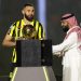 Former Real Madrid striker Karim Benzema hoists the Ballon d'Or, the trophy he won last year, above his head, at King Abdullah Sports City stadium in Jeddah, on June 8, 2023. - Benzema was unveiled as an Al-Ittihad player in front of thousands of fans in Saudi Arabia on June 8, a day after the oil-rich kingdom just failed to reel in Lionel Messi. (Photo by - / AFP)