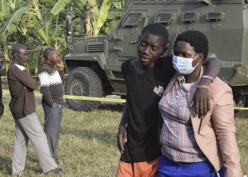 Un chico es confortado en la escena del ataque en  Mpondwe, Uganda, el 17 de junio de 2023. Foto: AFP