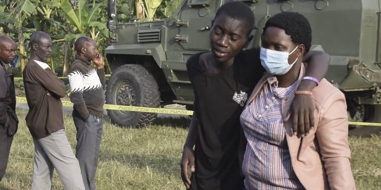 Un chico es confortado en la escena del ataque en  Mpondwe, Uganda, el 17 de junio de 2023. Foto: AFP