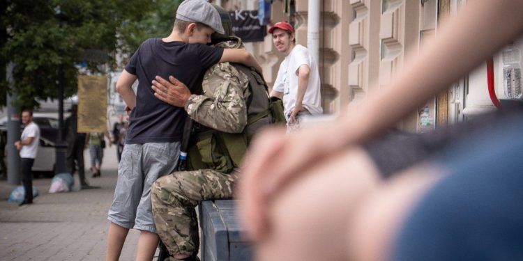 Un niño abraza a un miembro del grupo Wagner en Rostov-on-Don, el 24 de junio de 2023. El presidente Vladimir Putin dijo el 24 de junio de 2023 que un motín armado de mercenarios de Wagner fue una "puñalada por la espalda" y que el jefe del grupo Yevgeny Prigozhin había traicionado a Rusia, ya que prometió castigar a los disidentes. Prigozhin dijo que sus combatientes controlan sitios militares clave en la ciudad sureña de Rostov-on-Don. (Foto de Denis ROMANOV / AFP)