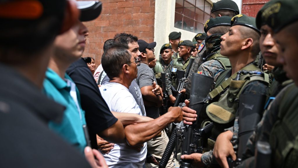 Los votantes se enfrentan a los soldados frente a un centro de votación que permanece cerrado tras presuntas amenazas e irregularidades durante las elecciones generales, en San José del Golfo, en las afueras del norte de la ciudad de Guatemala el 25 de junio de 2023. La nación más poblada de América Central, Guatemala, vota por un nuevo presidente que algunos esperan, pero pocos esperan, que finalmente se resuelvan los problemas de aplastamiento de la pobreza, la violencia y la corrupción. (Foto por Johan ORDONEZ / AFP)