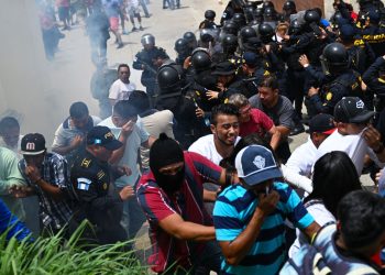 Votantes que protestan chocan con agentes de policía frente a un centro de votación que permanece cerrado tras presuntas amenazas e irregularidades durante las elecciones generales, en San José del Golfo, en las afueras del norte de la Ciudad de Guatemala el 25 de junio de 2023. Residentes de dos municipios guatemaltecos se enfrentaron a agentes de policía que lanzaron gases lacrimógenos para disolver las protestas por supuestas anomalías en las elecciones generales del domingo, dijeron las autoridades. Los hechos ocurrieron en San José del Golfo, en la periferia nororiental de la capital, donde se suspendió la votación, así como en San Martín Zapotitlán, al sur de Ciudad de Guatemala, según informó el ente electoral. (Foto por Johan ORDONEZ / AFP)