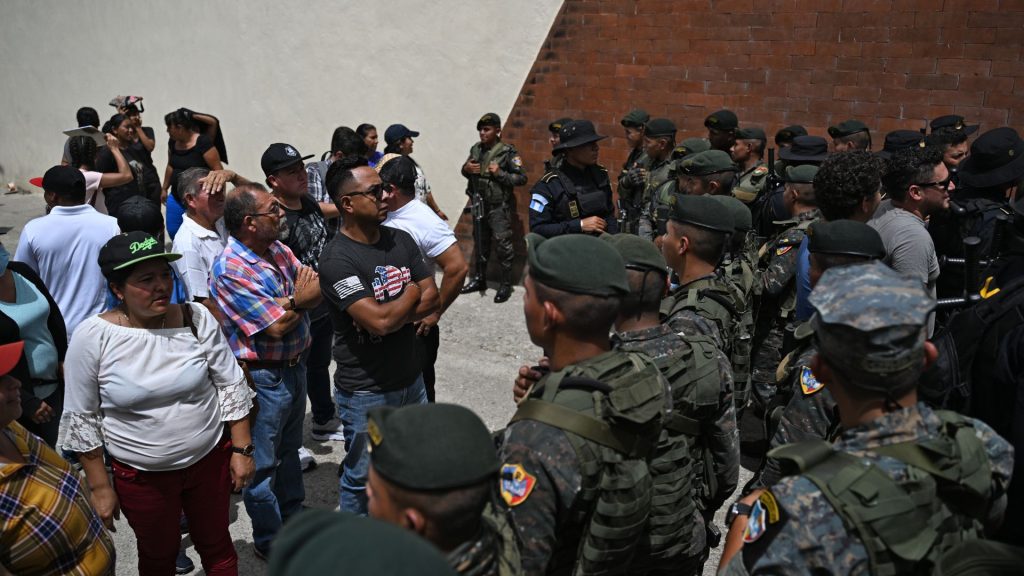 Los soldados montan guardia para evitar que los votantes lleguen a un centro de votación que permanece cerrado luego de presuntas amenazas e irregularidades durante las elecciones generales, en San José del Golfo, en las afueras del norte de la ciudad de Guatemala el 25 de junio de 2023. La nación más poblada de América Central, Guatemala, vota por un nuevo presidente que algunos esperan, pero pocos esperan, finalmente resolverá los problemas de aplastamiento de la pobreza, la violencia y la corrupción. (Foto por Johan ORDONEZ / AFP)