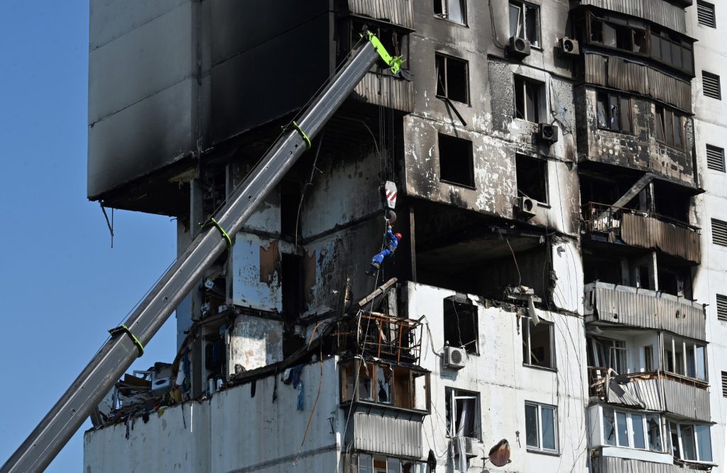 Un miembro de los servicios de rescate de emergencia es colocado frente a un edificio residencial dañado en Kiev el 22 de junio de 2023, luego de una explosión e incendio en los edificios de apartamentos.
