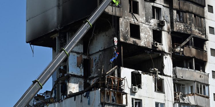 Un miembro de los servicios de rescate de emergencia es colocado frente a un edificio residencial dañado en Kiev el 22 de junio de 2023, luego de una explosión e incendio en los edificios de apartamentos.