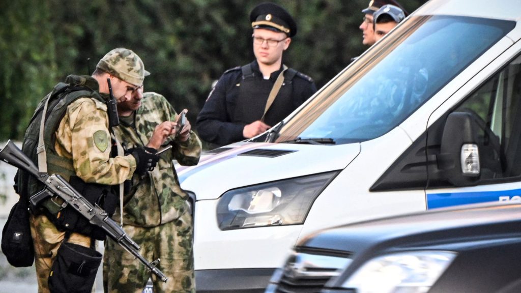 Soldados y policías rusos se paran al borde de una de las carreteras que ingresan a Moscú el 24 de junio de 2023. El jefe de la fuerza mercenaria rebelde de Wagner, Yevgeny Prigozhin, amenazó con marchar sobre Moscú el sábado antes de anunciar un sorprendente retroceso, diciendo que no ganas de derramar sangre. (Foto de Alexander NEMENOV / AFP)