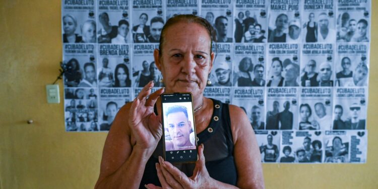 Liset Fonseca muestra una foto de su hijo Roberto Pérez Fonseca, detenido por participar en las protestas contra el gobierno en la provincia de San José de las Lajas, Mayabeque, Cuba. Foto: AFP