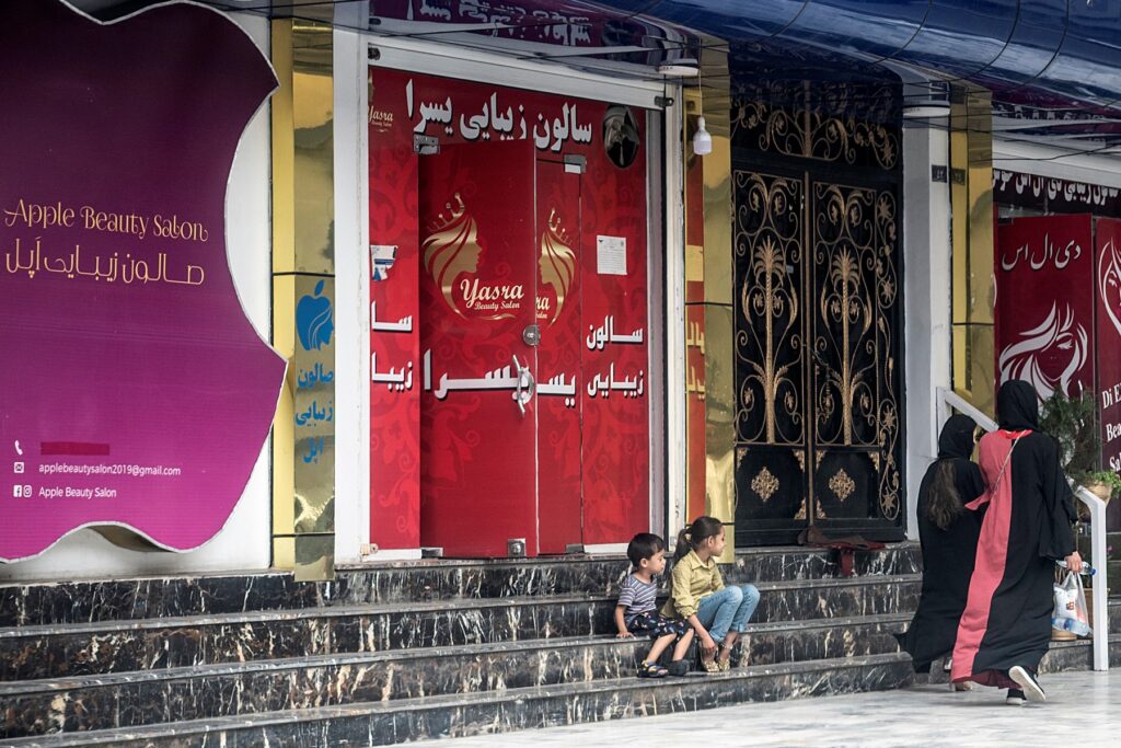Las mujeres pasan frente a un salón de belleza en el área de Shahr-e Naw en Kabul el 4 de julio de 2023. - Las autoridades talibanes de Afganistán ordenaron el cierre de los salones de belleza en todo el país dentro de un mes, confirmó el viceministerio el 4 de julio, la última restricción a Excluir aún más a las mujeres de la vida pública. (Foto de Wakil KOHSAR / AFP)