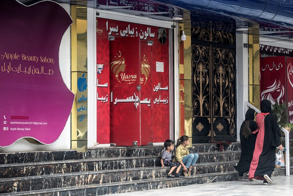 Las mujeres pasan frente a un sal&oacute;n de belleza en el &aacute;rea de Shahr-e Naw en Kabul el 4 de julio de 2023. - Las autoridades talibanes de Afganist&aacute;n ordenaron el cierre de los salones de belleza en todo el pa&iacute;s dentro de un mes, confirm&oacute; el viceministerio el 4 de julio, la &uacute;ltima restricci&oacute;n a Excluir a&uacute;n m&aacute;s a las mujeres de la vida p&uacute;blica. (Foto de Wakil KOHSAR / AFP)