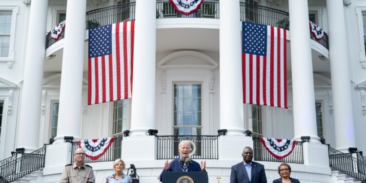 El presidente estadounidense Joe Biden habla junto a la primera dama Jill Biden (izquierda) y el secretario de Defensa Lloyd Austin (derecha) durante una barbacoa para las familias de militares en servicio activo en honor del 4 de julio en el jardín sur de la Casa Blanca en Washington, D.C. , 4 de julio de 2023. (Foto de SAUL LOEB / AFP)