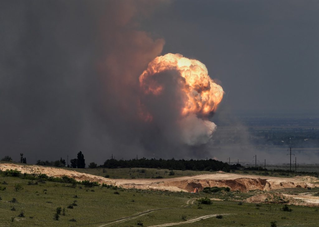 Una imagen muestra la detonación de municiones causada por un incendio en un campo de entrenamiento militar en el distrito Kirovsky de Crimea el 19 de julio de 2023. - El presidente ruso, Vladimir Putin, ha sido informado sobre un incendio en un sitio militar en Crimea, anexada a Moscú, que obligó a las autoridades a evacuar a miles de civiles el 19 de julio de 2023, dijo el Kremlin. La noticia del incendio se produjo dos días después de que Ucrania utilizara drones acuáticos para atacar el puente de Kerch, una arteria de suministro militar clave desde la parte continental de Rusia hasta la Crimea anexada. Las autoridades ordenaron la evacuación de más de 2.000 residentes de las zonas cercanas al campo militar. Una sección de la carretera de Tavrida, que conecta el puerto de Kerch, en el este de Crimea, con el puerto de Sebastopol en la costa del Mar Negro de la península, se cerró debido al incendio. (Foto de Viktor KOROTAYEV / Kommersant Photo / AFP) / Rusia FUERA / RUSIA FUERA