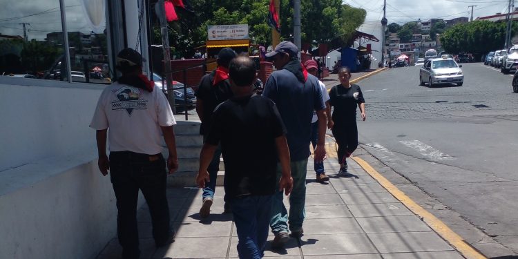 Militantes sandinistas y trabajadores del sector público portando pañoletas, gorras y souvenires afines al Sandinism