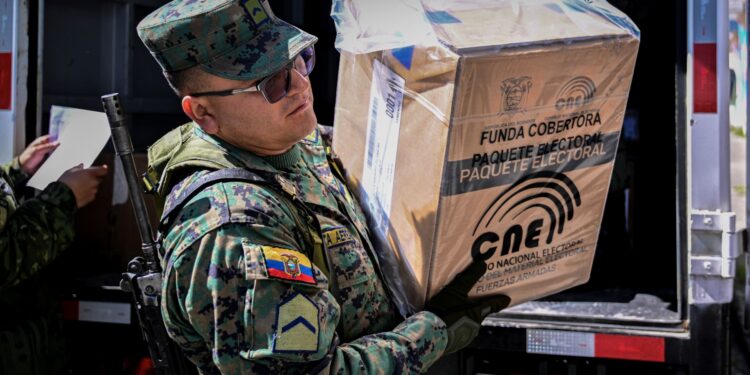 A member of the Armed Forces distributes electoral material across polling station in Quito on August 19, 2023, on the eve of the presidential election and referendum on mining and petroleum. - Ecuador holds a presidential election on Sunday after a campaign marked by the murder of a top candidate and vows to tackle the lawlessness that has engulfed the once-peaceful nation. Alongside the presidential vote, two key referendums are taking place in one of the world's most biodiverse countries. One will ask voters to choose whether to continue oil drilling in the Amazon, and another focuses on whether to forbid mining activities in the Choco Andino forest. (Photo by Martin BERNETTI / AFP)