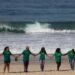 Voluntarios de una Organización No Gubernamental se dan la mano después de limpiar la playa de Sao Conrado en Río de Janeiro, Brasil, el 8 de junio de 2023 en el marco del Día Mundial de los Océanos. (Foto de Joao Laet / AFP)
