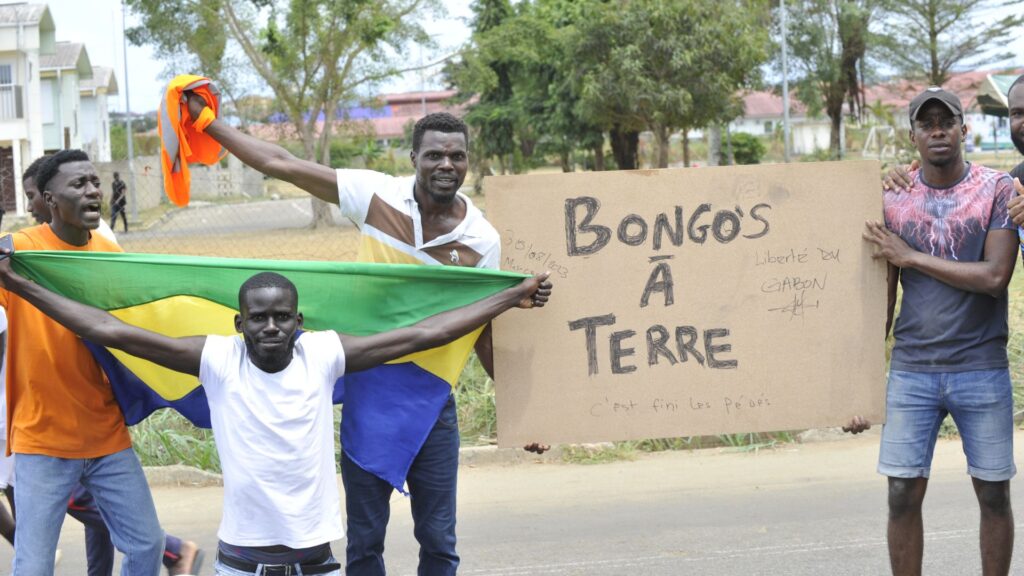 Los residentes sostienen una bandera nacional de Gabón mientras celebran en Libreville el 30 de agosto de 2023 después de que un grupo de oficiales militares gaboneses aparecieran en la televisión anunciando que estaban "poniendo fin al régimen actual". Foto: Artículo 66 / AFP