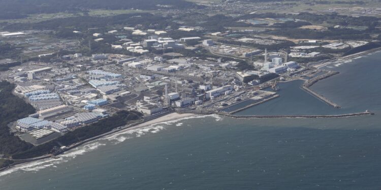 Esta imagen aérea muestra los tanques de almacenamiento (L) utilizados para almacenar agua tratada en la averiada planta de energía nuclear Fukushima Daiichi de TEPCO en Okuma, prefectura de Fukushima, el 24 de agosto de 2023. - Japón comenzó a liberar aguas residuales de la averiada planta nuclear de Fukushima en el Océano Pacífico en agosto 24 a pesar de la airada oposición de China y los pescadores locales. (Foto de STR / JIJI PRESS / AFP) / Japón FUERA / JAPÓN FUERA