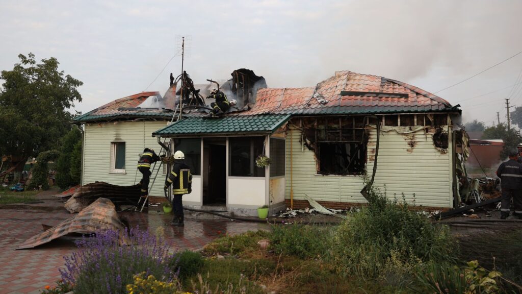 Los bomberos extinguen un incendio en una casa que resultó dañada tras un ataque con misiles en una aldea en las afueras de Kiev el 30 de agosto de 2023, en medio de la invasión rusa de Ucrania. (Foto de Anatolii STEPANOV / AFP)