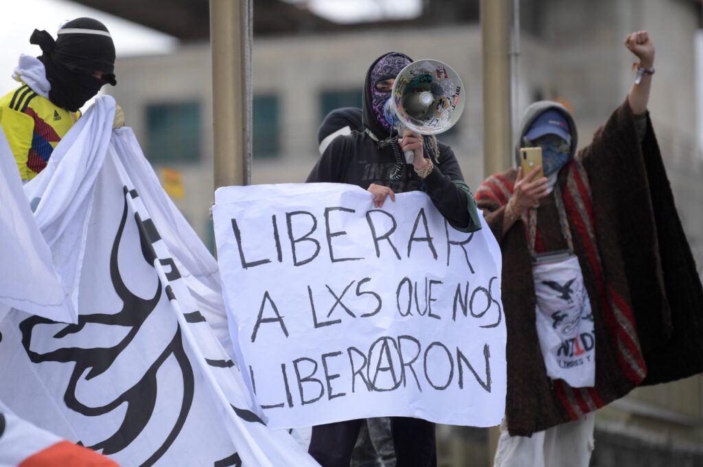 Miembros de la llamada primera línea realizan una protesta exigiendo la libertad de los presos políticos -arrestados durante las movilizaciones de 2021- frente a la fiscalía, en Bogotá, el 28 de octubre de 2022. (Foto de Raúl ARBOLEDA / AFP)