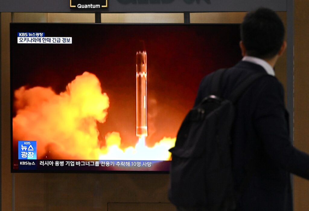 Un hombre pasa junto a una pantalla de televisión que muestra un noticiero con imágenes de archivo de una prueba de misiles norcoreanos, en una estación de tren en Seúl el 24 de agosto de 2023. - El último intento de Corea del Norte de poner en órbita un satélite espía ha terminado en fracaso. dijeron los medios estatales el 24 de agosto, pocos meses después de que el primer lanzamiento de Pyongyang se estrellara en el océano poco después del despegue. (Foto de Jung Yeon-je / AFP)