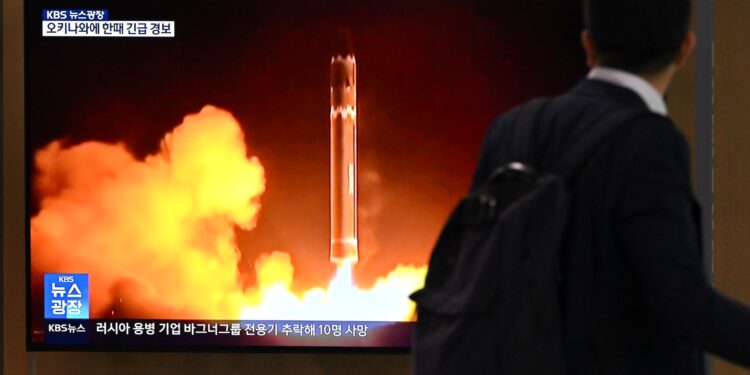 Un hombre pasa junto a una pantalla de televisión que muestra un noticiero con imágenes de archivo de una prueba de misiles norcoreanos, en una estación de tren en Seúl el 24 de agosto de 2023. - El último intento de Corea del Norte de poner en órbita un satélite espía ha terminado en fracaso. dijeron los medios estatales el 24 de agosto, pocos meses después de que el primer lanzamiento de Pyongyang se estrellara en el océano poco después del despegue. (Foto de Jung Yeon-je / AFP)